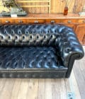 Grand canapé chesterfield en cuir noir side top