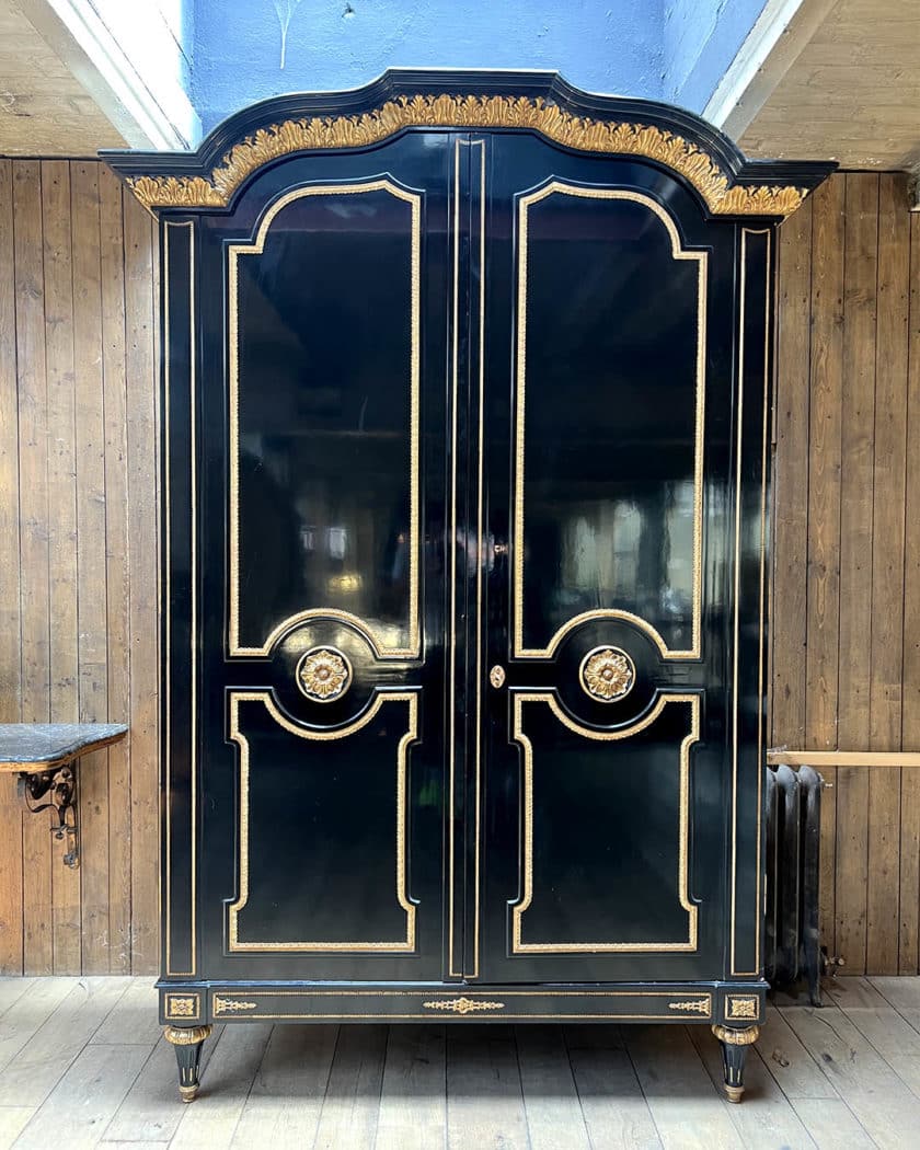 Grande armoire en bois noirci et bois doré
