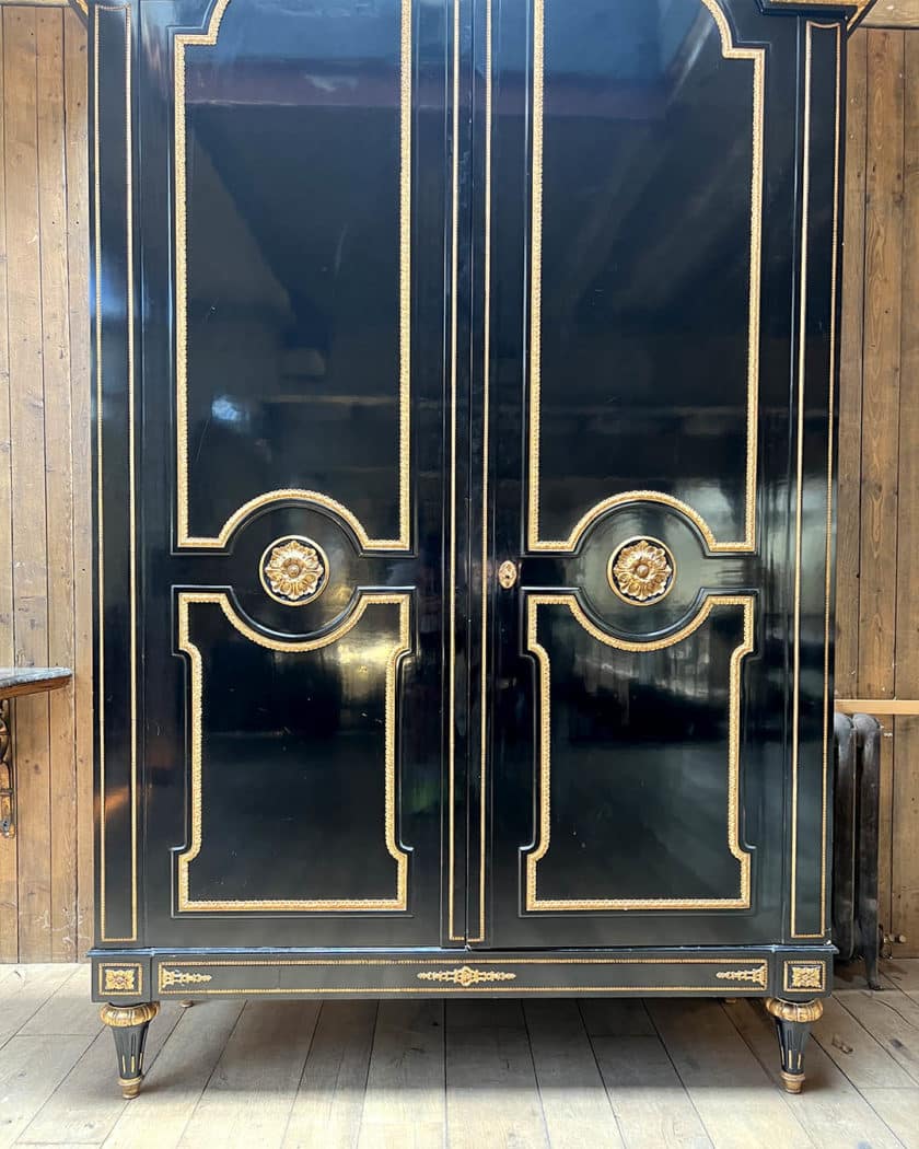 Grande armoire en bois noirci et bois doré
