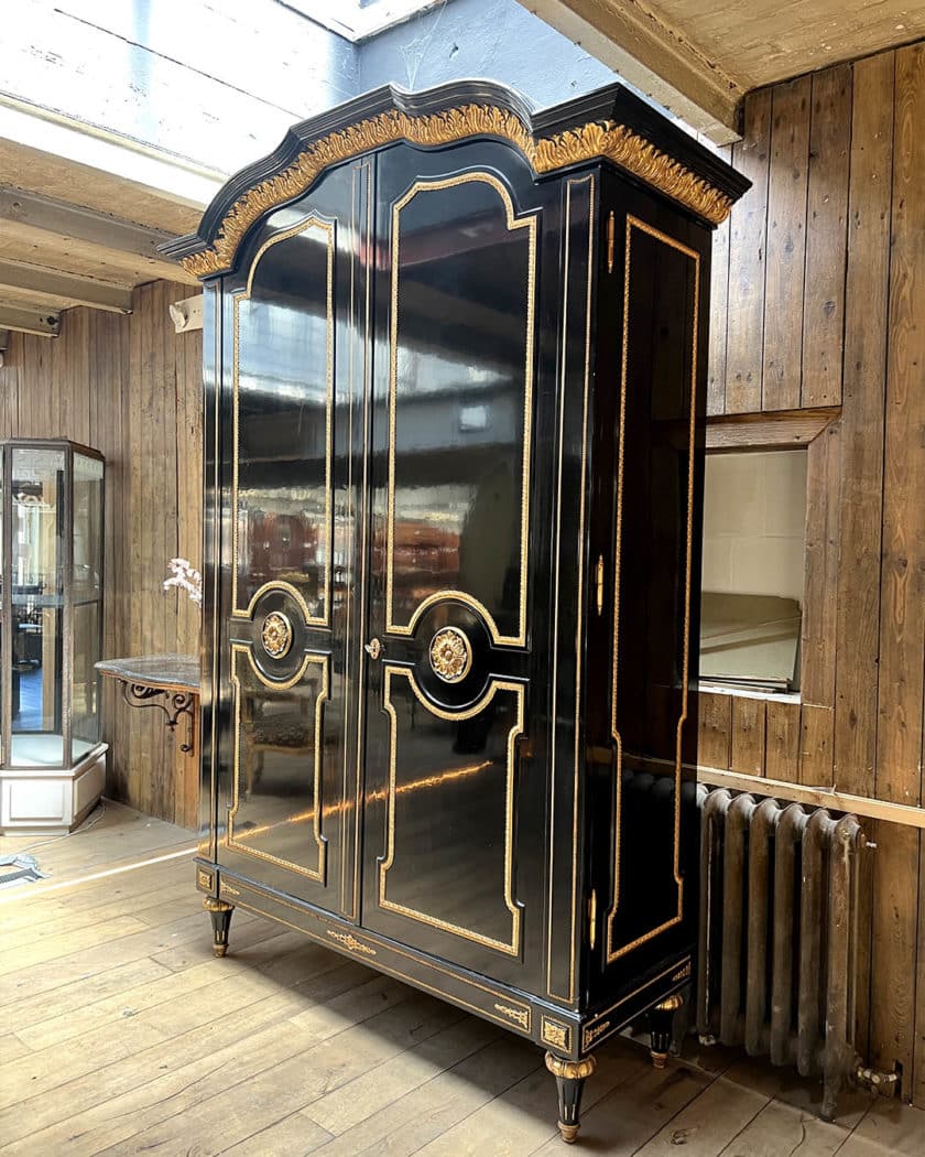 Grande armoire en bois noirci et bois doré