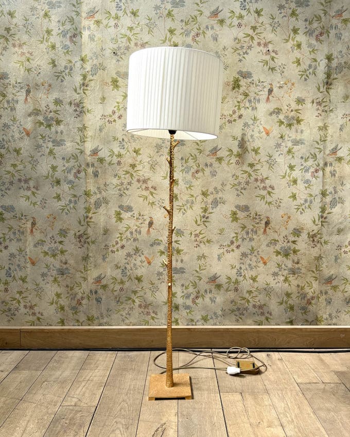Un lampadaire en métal martelé doré