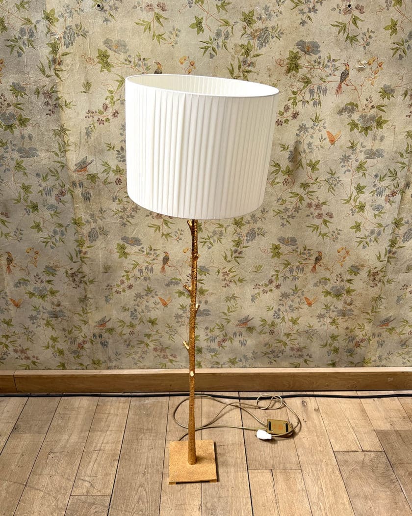 Un lampadaire en métal martelé doré