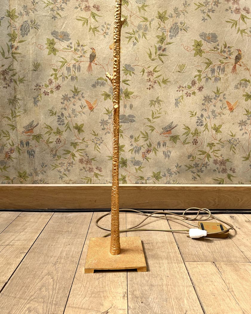 Un lampadaire en métal martelé doré