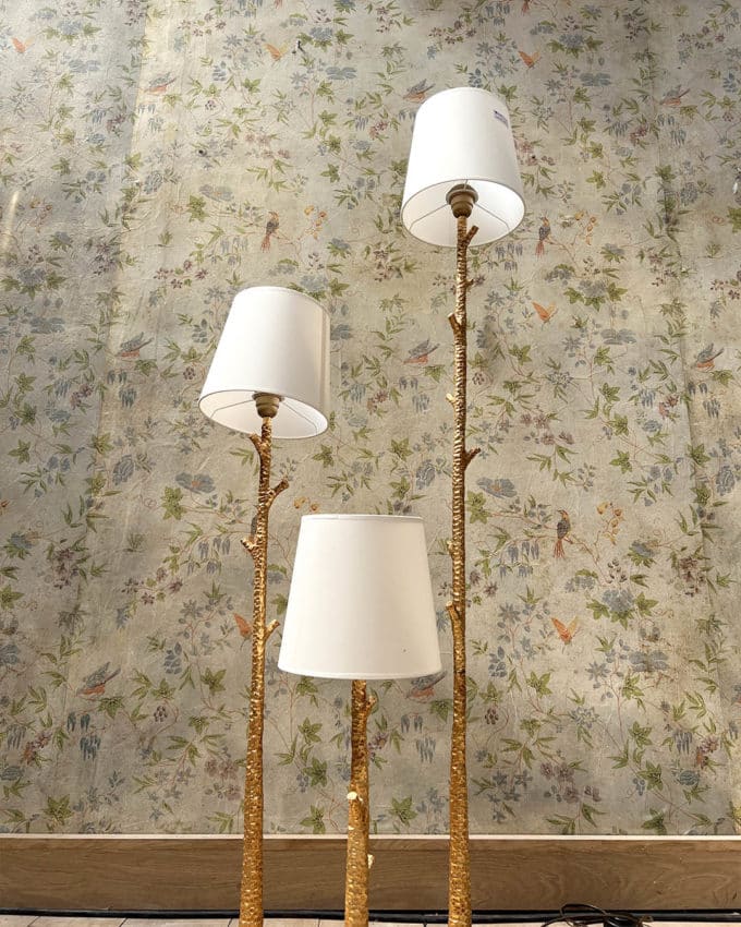 Un lampadaire en métal martelé doré à trois bras de lumière