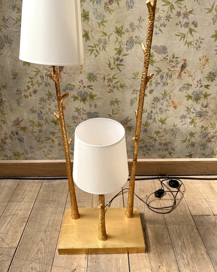 Un lampadaire en métal martelé doré à trois bras de lumière