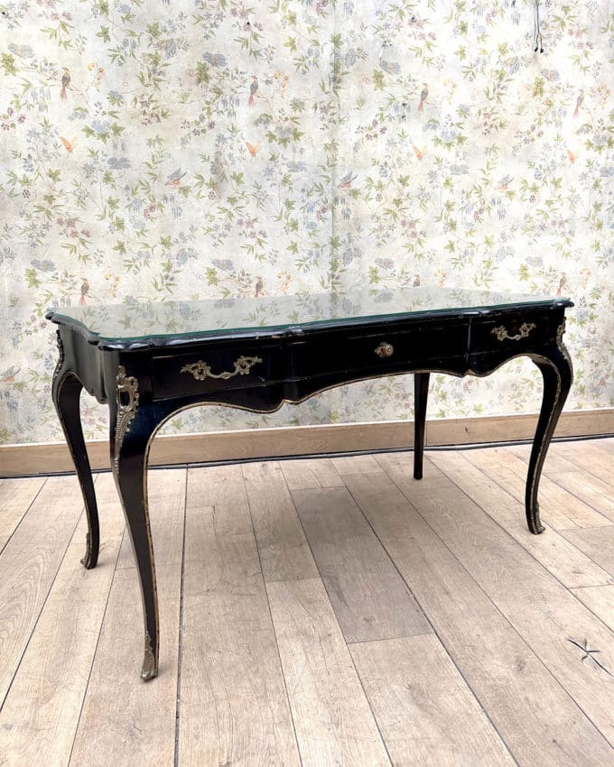 Bureau plat en bois noirci et doré de forme mouvementée