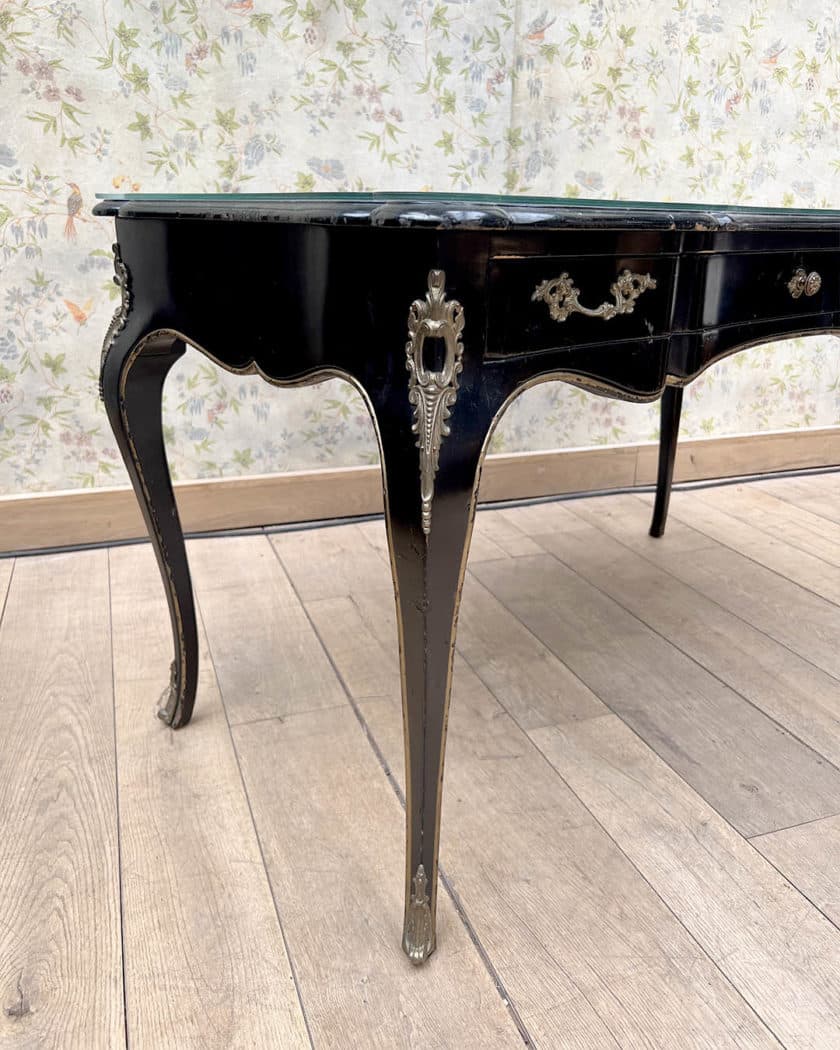 Bureau plat en bois noirci et doré de forme mouvementée