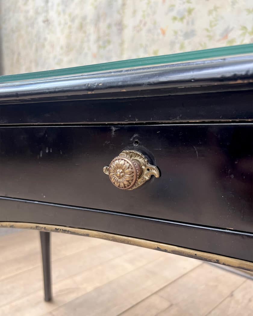 Bureau plat en bois noirci et doré de forme mouvementée