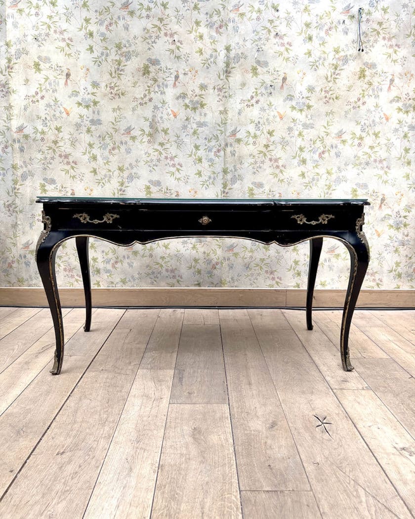 Bureau plat en bois noirci et doré de forme mouvementée