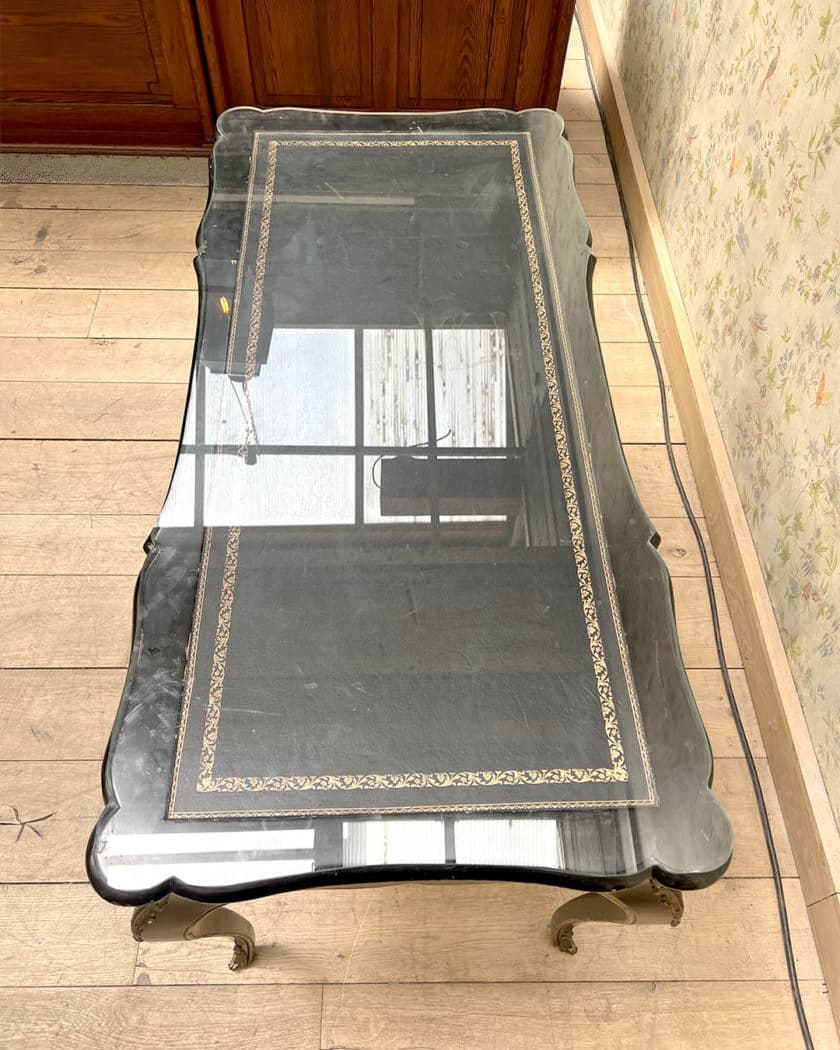 Bureau plat en bois noirci et doré de forme mouvementée