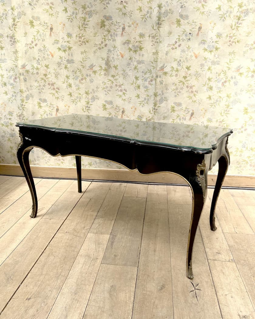 Bureau plat en bois noirci et doré de forme mouvementée