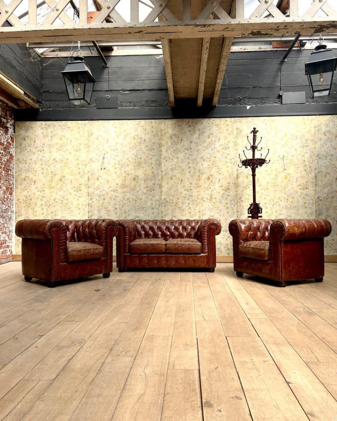 Salon chesterfield avec un canapé et deux fauteuils