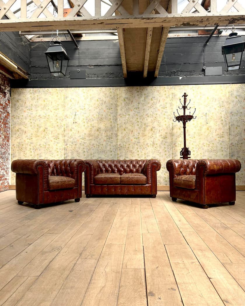 Salon chesterfield avec un canapé et deux fauteuils