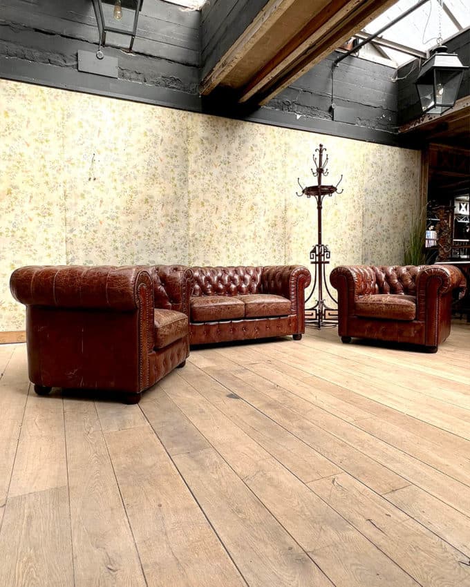 Salon chesterfield avec un canapé et deux fauteuils
