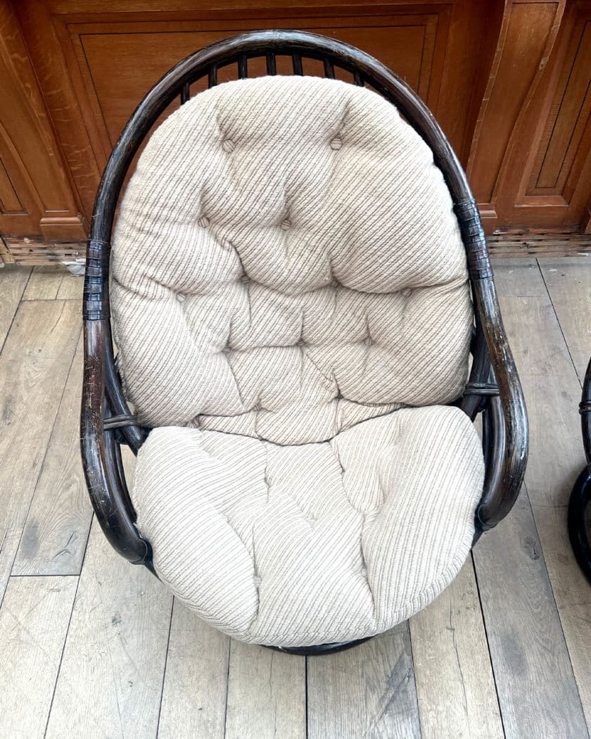 Paire de fauteuils en rotin noirci avec coussins capitonnés beiges
